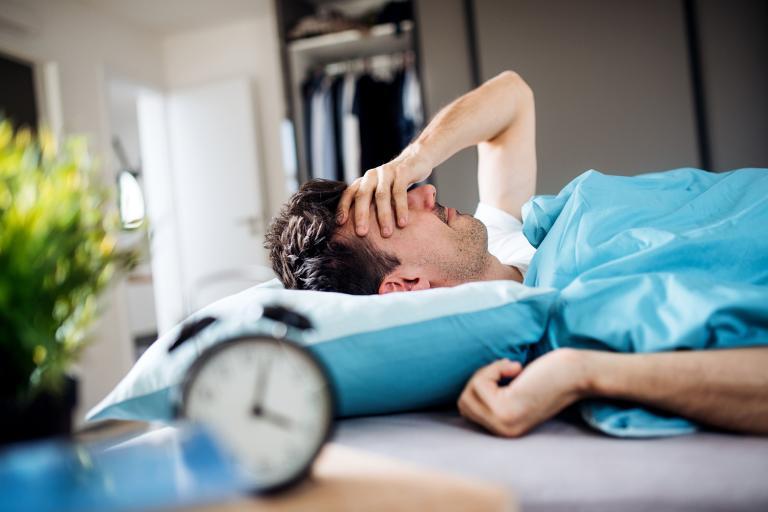 a man waking up, still tired, after not sleeping well