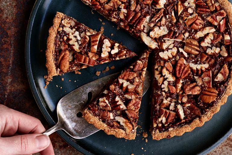 Pumpkin Pecan Tart being sliced and served.